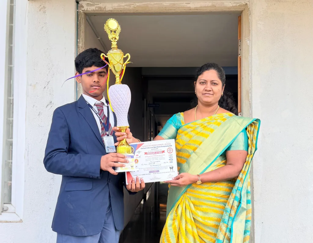 Janith of Grade 9 receiving a karate trophy and certificate at BRS Global School Attibele, one of the best schools in Sarjapur Road.